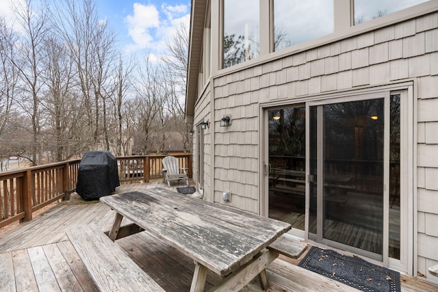 wooden deck with outdoor dining area and a grill