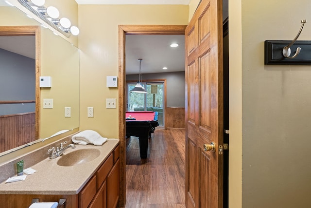 bathroom featuring vanity, wood finished floors, and pool table