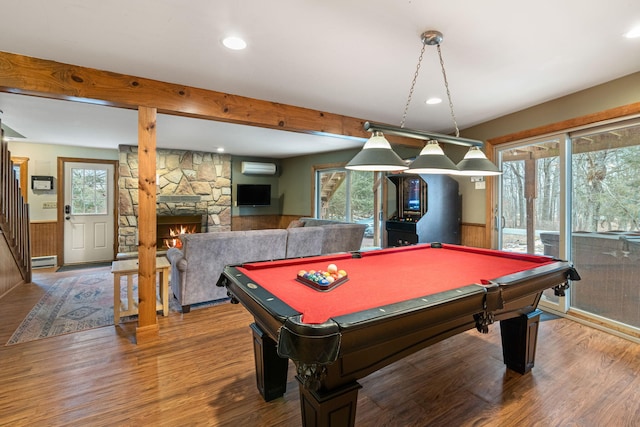 recreation room featuring baseboard heating, an AC wall unit, wainscoting, wood finished floors, and beamed ceiling