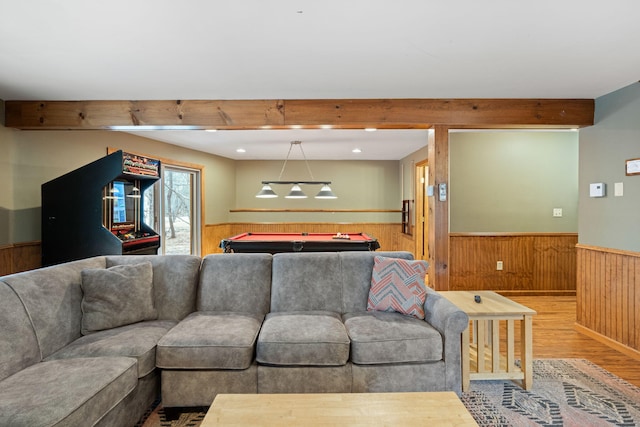 living room with wainscoting, wood finished floors, pool table, wood walls, and beam ceiling