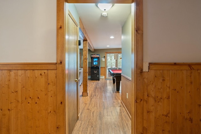 hall with a wainscoted wall, wooden walls, recessed lighting, and light wood-style floors