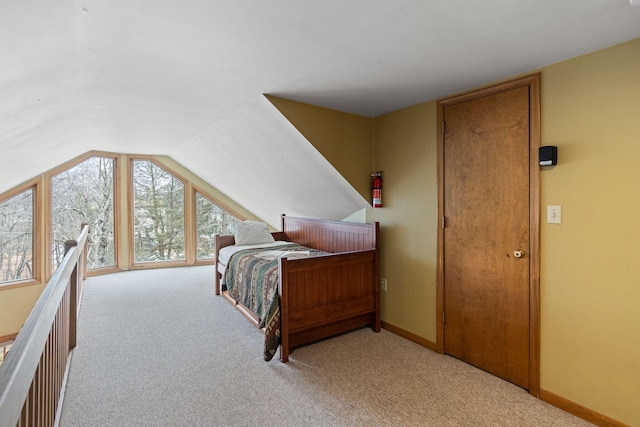 bedroom with carpet floors, baseboards, and lofted ceiling