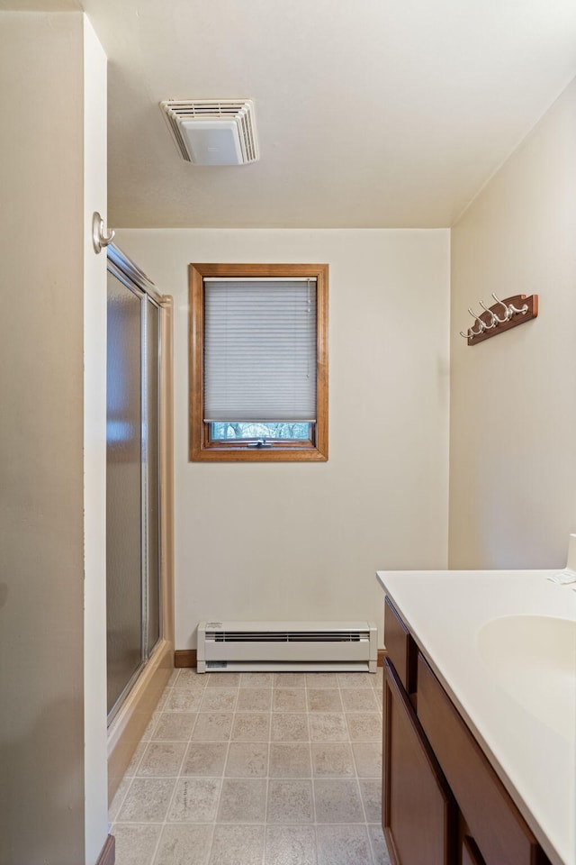 full bathroom featuring a baseboard heating unit, a stall shower, visible vents, and vanity