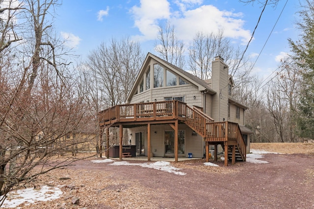 rear view of house featuring a chimney, a patio area, a jacuzzi, a wooden deck, and stairs