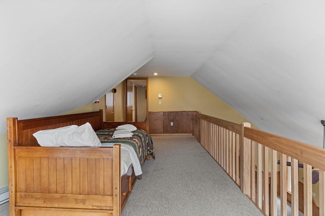 bedroom featuring lofted ceiling, wood walls, carpet floors, and wainscoting