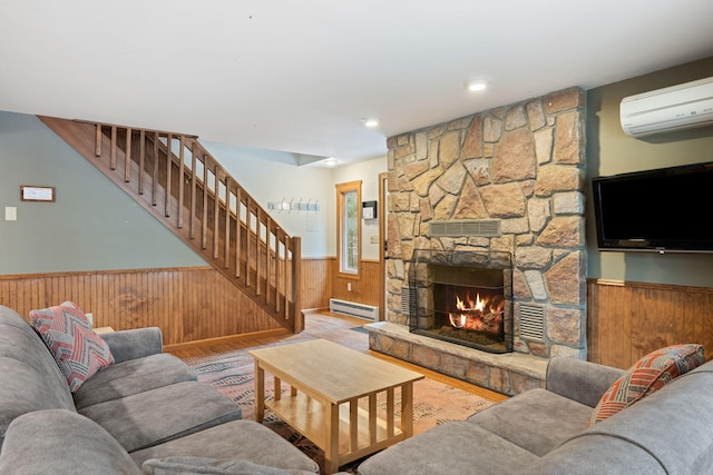 living area featuring wooden walls, a wainscoted wall, stairs, baseboard heating, and a fireplace