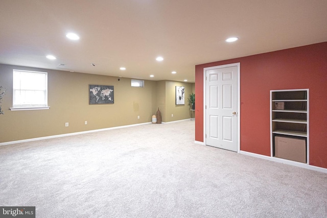 below grade area with recessed lighting, light carpet, and baseboards