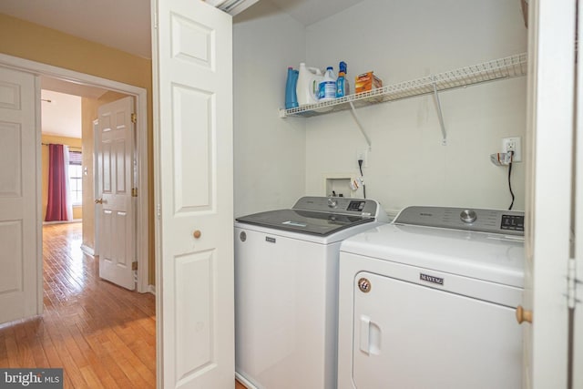 clothes washing area featuring laundry area, washing machine and dryer, and light wood-style floors