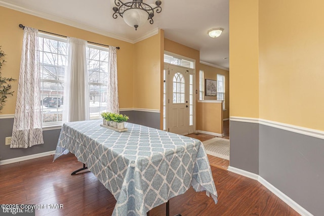 dining room featuring ornamental molding, dark wood-style flooring, and baseboards