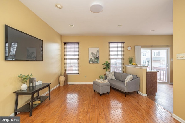 living area featuring light wood finished floors, baseboards, and a wealth of natural light