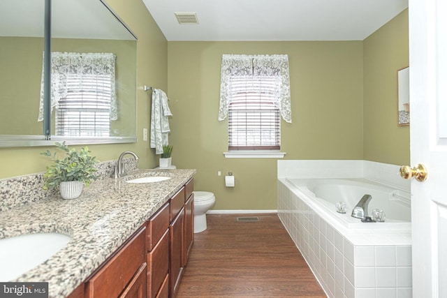 full bathroom featuring wood finished floors, a sink, visible vents, baseboards, and a bath