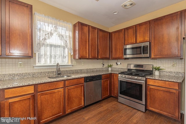 kitchen with stainless steel appliances, a sink, visible vents, dark wood-style floors, and tasteful backsplash