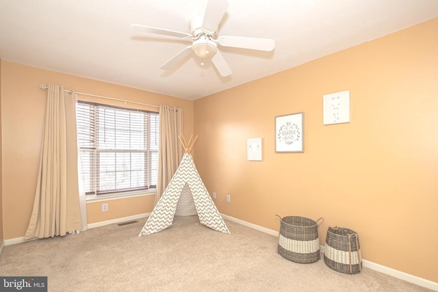 playroom featuring carpet flooring, a ceiling fan, and baseboards