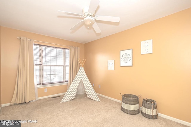 recreation room featuring carpet floors, a ceiling fan, and baseboards