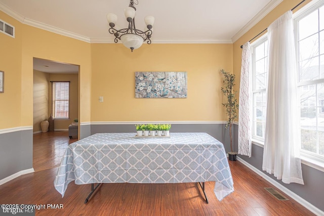 dining area featuring a wealth of natural light, visible vents, and crown molding