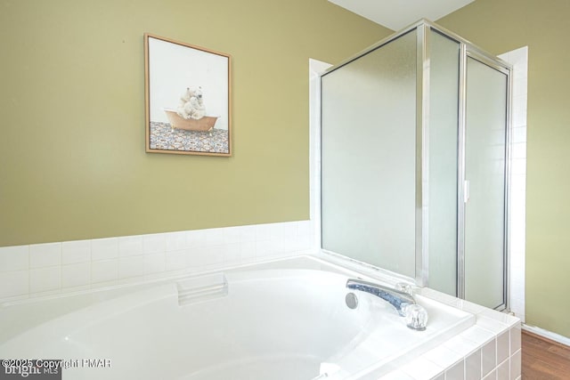 bathroom featuring a garden tub and a shower stall