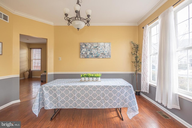 dining space with a wealth of natural light, visible vents, and crown molding