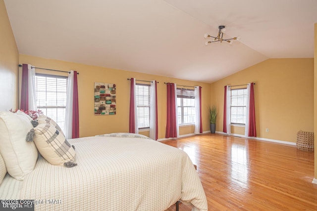 bedroom featuring light wood-style floors, baseboards, and vaulted ceiling