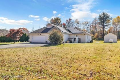 view of front facade featuring a garage, aphalt driveway, and a front lawn