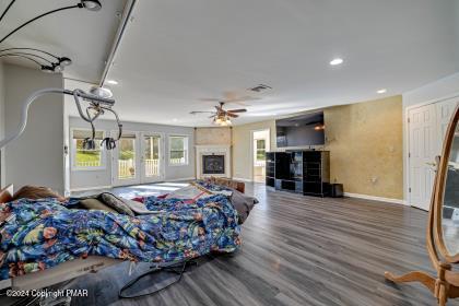 bedroom featuring recessed lighting, a fireplace, baseboards, and wood finished floors