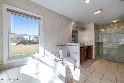 full bathroom with toilet, vanity, tile patterned floors, a stall shower, and a tub