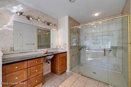 bathroom with tile patterned flooring, a shower stall, and vanity