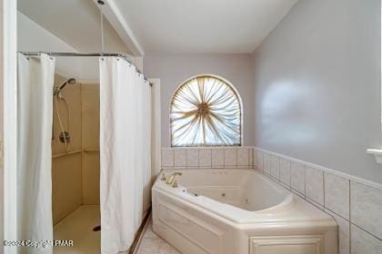 full bathroom with a tub with jets, tile walls, and a shower with shower curtain