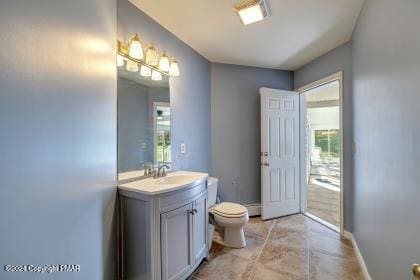 bathroom with a baseboard radiator, baseboards, vanity, and toilet