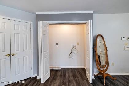 hall featuring dark wood-style floors and baseboards