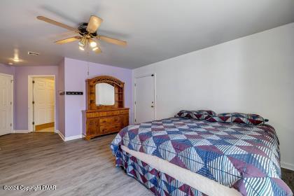 bedroom with a ceiling fan, baseboards, and wood finished floors