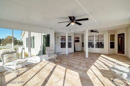 unfurnished sunroom featuring a ceiling fan