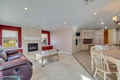 living room featuring a fireplace, visible vents, and recessed lighting