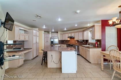 kitchen with under cabinet range hood, tasteful backsplash, a kitchen bar, and stainless steel appliances