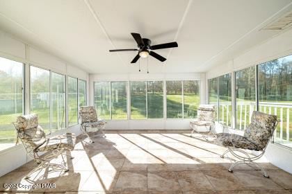 unfurnished sunroom featuring a ceiling fan