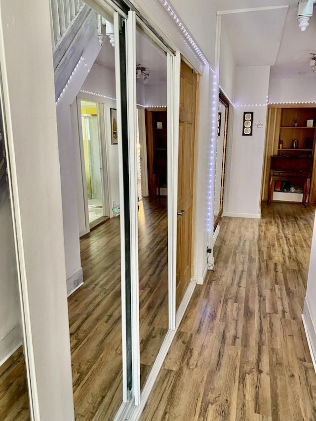 hallway featuring baseboards and wood finished floors