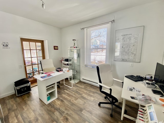 home office with a baseboard heating unit and dark wood-type flooring