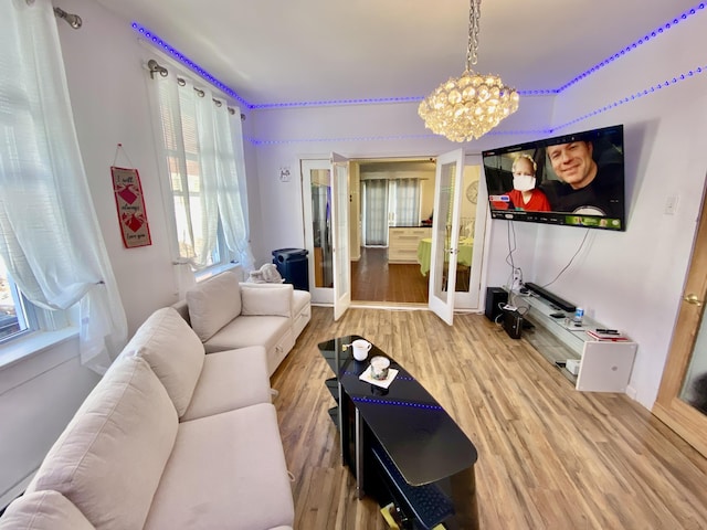 living area featuring a chandelier, french doors, and wood finished floors