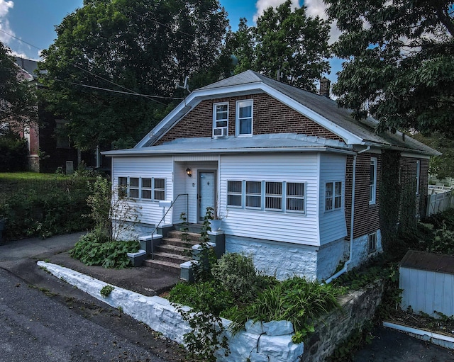 view of front of house with cooling unit and a chimney