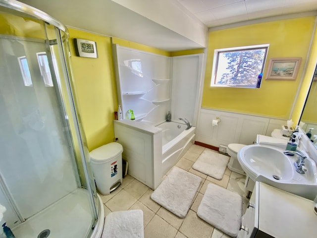 bathroom featuring vanity, a shower stall, toilet, and a wainscoted wall