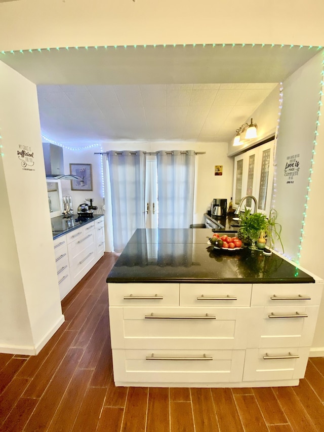 kitchen featuring dark countertops, white cabinets, and wood tiled floor