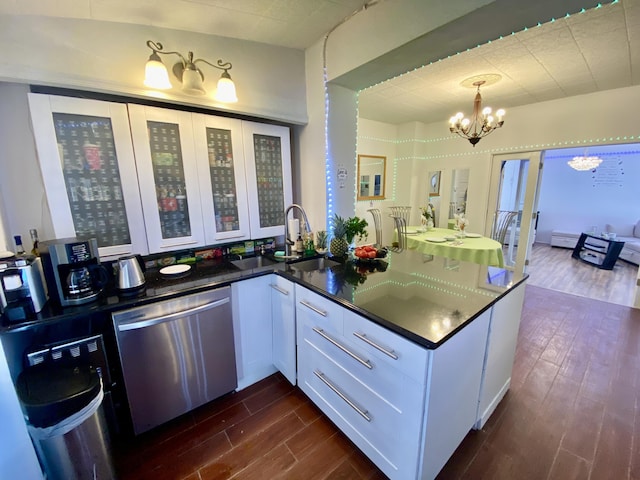 kitchen featuring dark wood-style floors, white cabinetry, a sink, dishwasher, and a chandelier