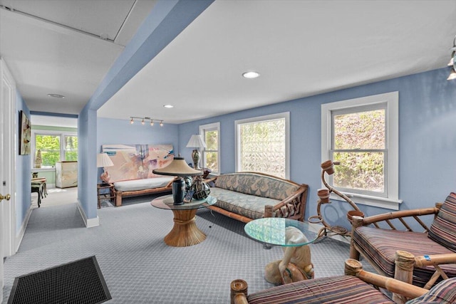 carpeted living area featuring baseboards, rail lighting, and recessed lighting