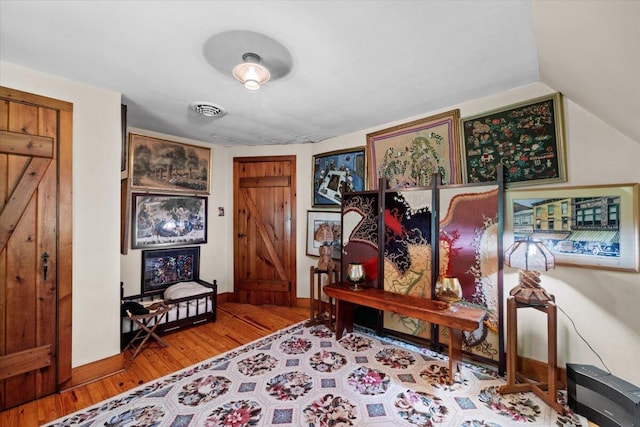 foyer entrance featuring wood finished floors, lofted ceiling, and baseboards