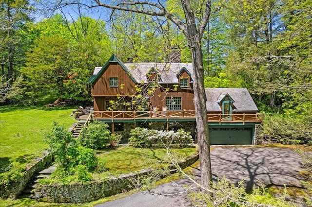 view of front facade featuring a garage, asphalt driveway, a front lawn, and stairway