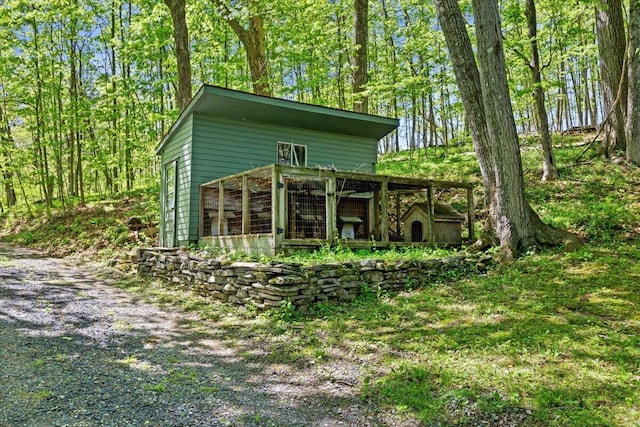 back of property featuring an outdoor structure