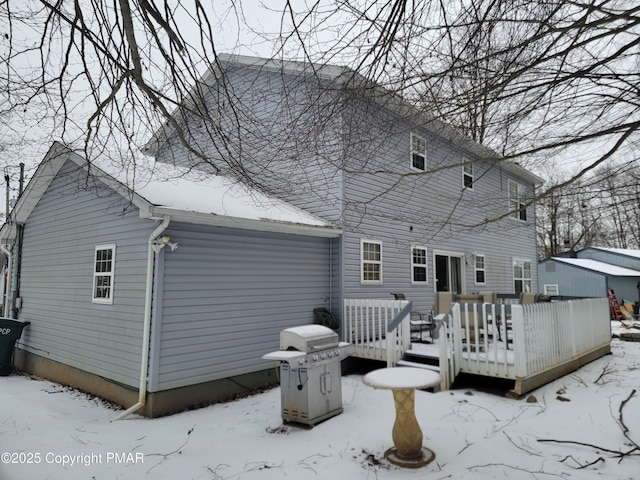 snow covered property featuring a deck