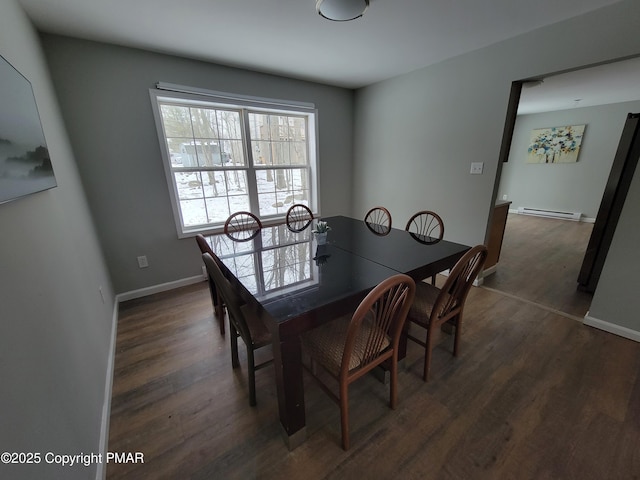 dining room with dark wood-type flooring and baseboard heating