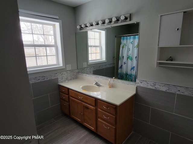 bathroom featuring tile walls, vanity, hardwood / wood-style floors, and walk in shower