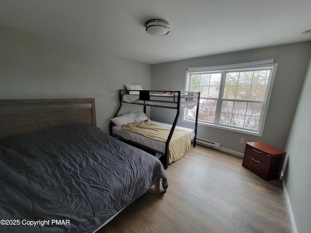 bedroom featuring a baseboard radiator and light hardwood / wood-style floors