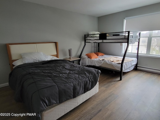 bedroom with hardwood / wood-style floors and baseboard heating